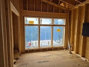 Multi-pane window installed in wood-framed opening during home renovation