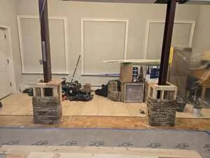 Interior framing with stud walls, brick columns, and drywall installation in progress