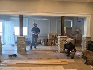 Interior renovation with exposed brick supports, new wood framing, and flooring preparation in progress