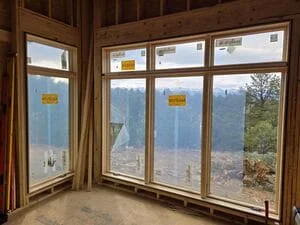 Multi-panel wooden casement windows with mountain valley views, professional framing installation