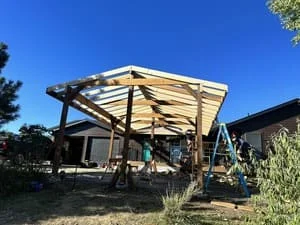 Wooden pergola with shade panels and beam framework in backyard setting