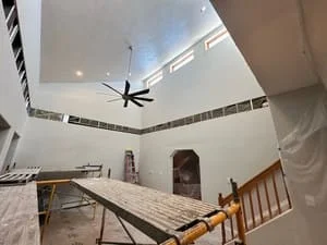 Two-story vaulted ceiling with skylight, recessed lighting, and ceiling fan installation