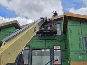 Heavy equipment with conveyor system transferring materials between trucks on construction site