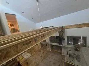 Interior framing with wooden studs and drywall sheets during construction phase