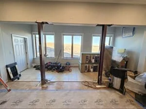 Interior renovation with support columns, new flooring, and finished walls and ceiling