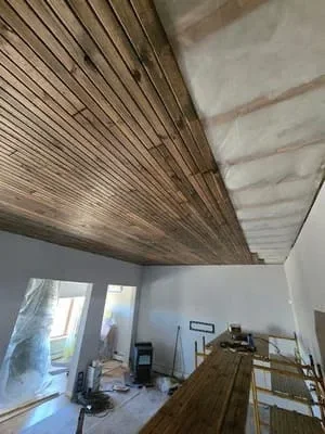 Vertical wood slat ceiling with warm stain finish installed in residential space