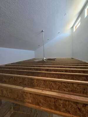 Wooden floor joists with drywall ceiling and recessed lighting installation