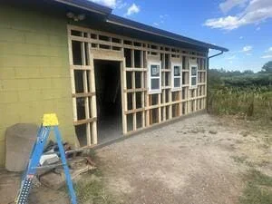Wood framed residential addition with window openings and entrance door during construction phase
