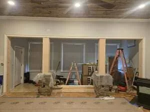 Metal stud framing and drywall installation in commercial interior space with three doorway openings